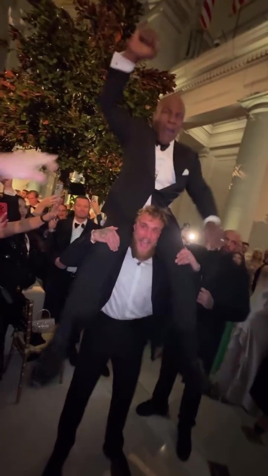 Jake Paul carrying Mike Tyson on his shoulders.