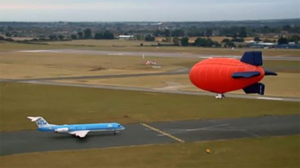 Airship and airplane on an airfield.