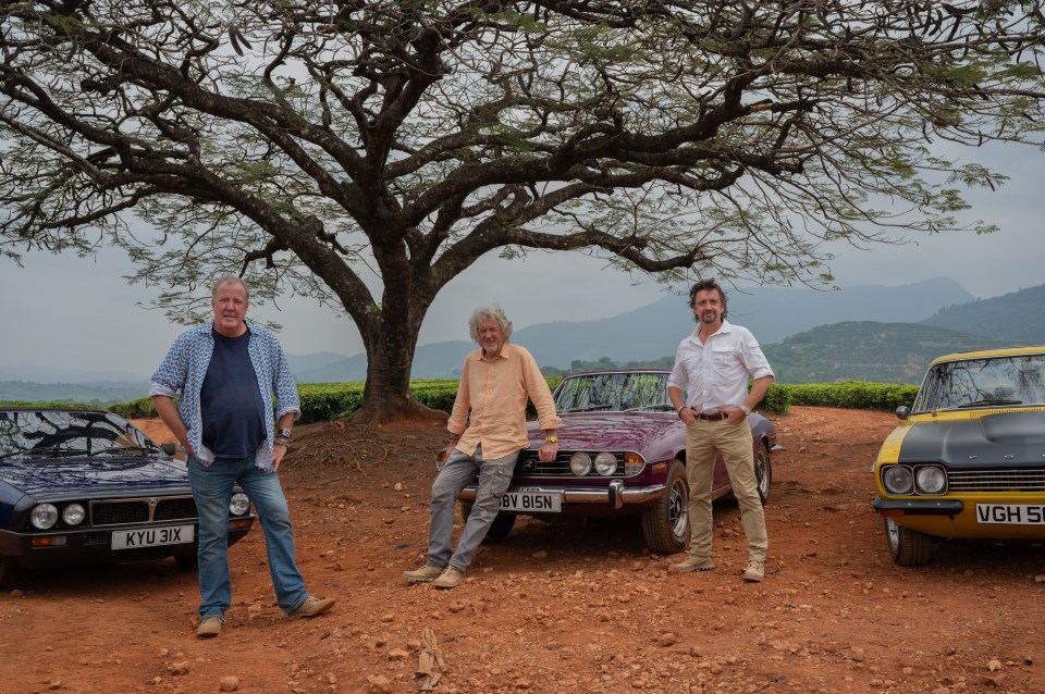 Jeremy Clarkson, James May, and Richard Hammond standing with their cars.