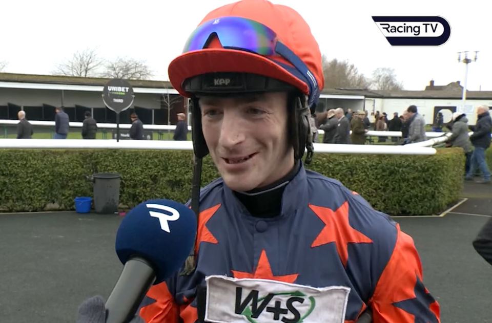 Jockey being interviewed at a racetrack.