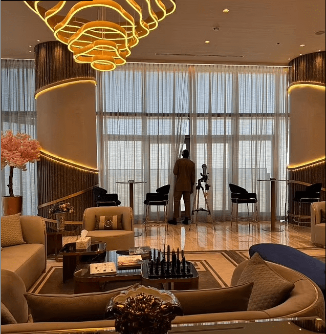 Man looking through telescope in luxurious living room.