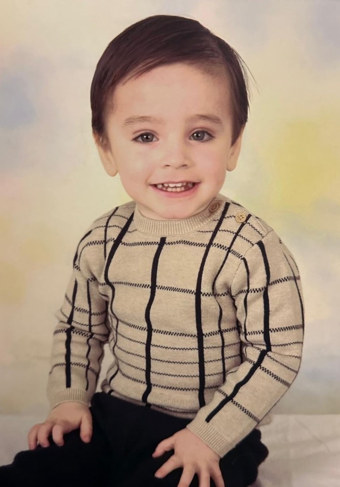 Photo of a toddler in a beige and black sweater.