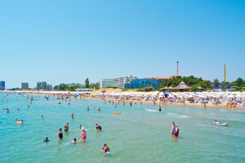 Sunny Beach in Bulgaria, crowded with people swimming and sunbathing.