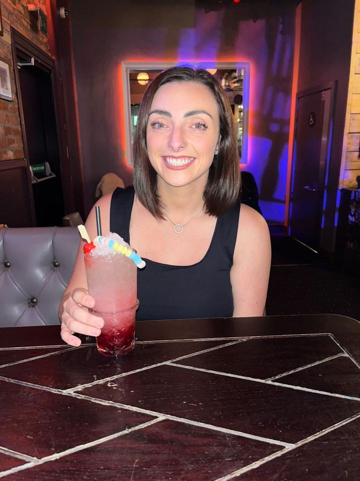 Woman holding a colorful cocktail.