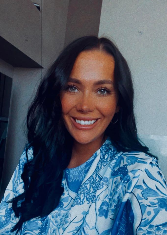 Headshot of a woman with long dark hair wearing a blue and white patterned top.