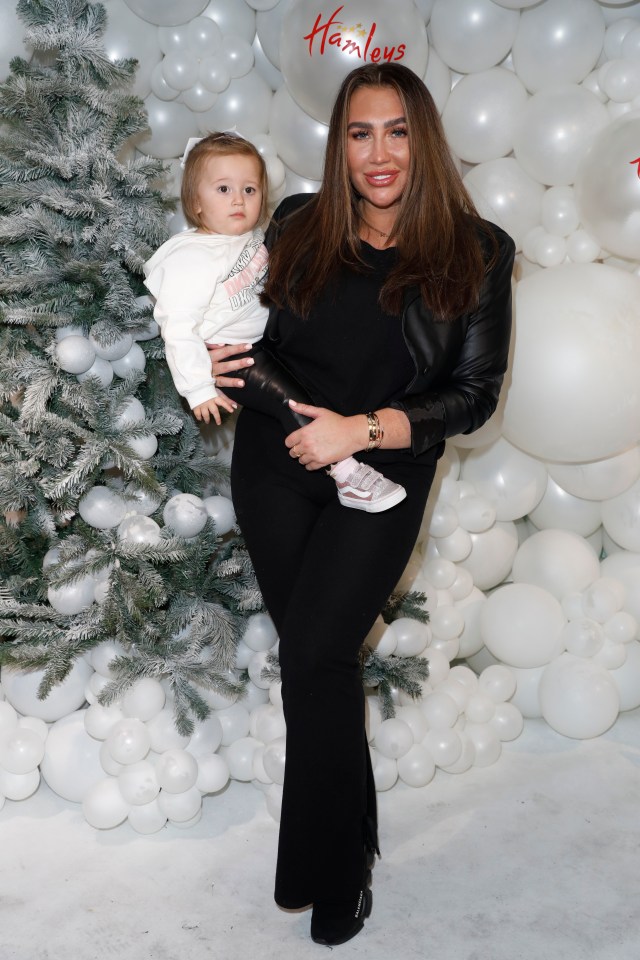 Lauren Goodger at a Christmas event, holding her young daughter.