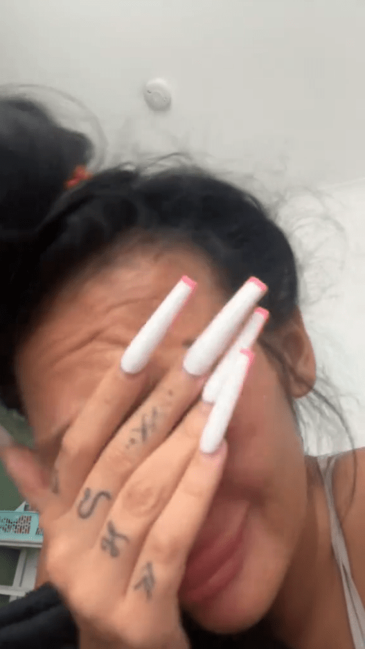 Person with long white nails crying.