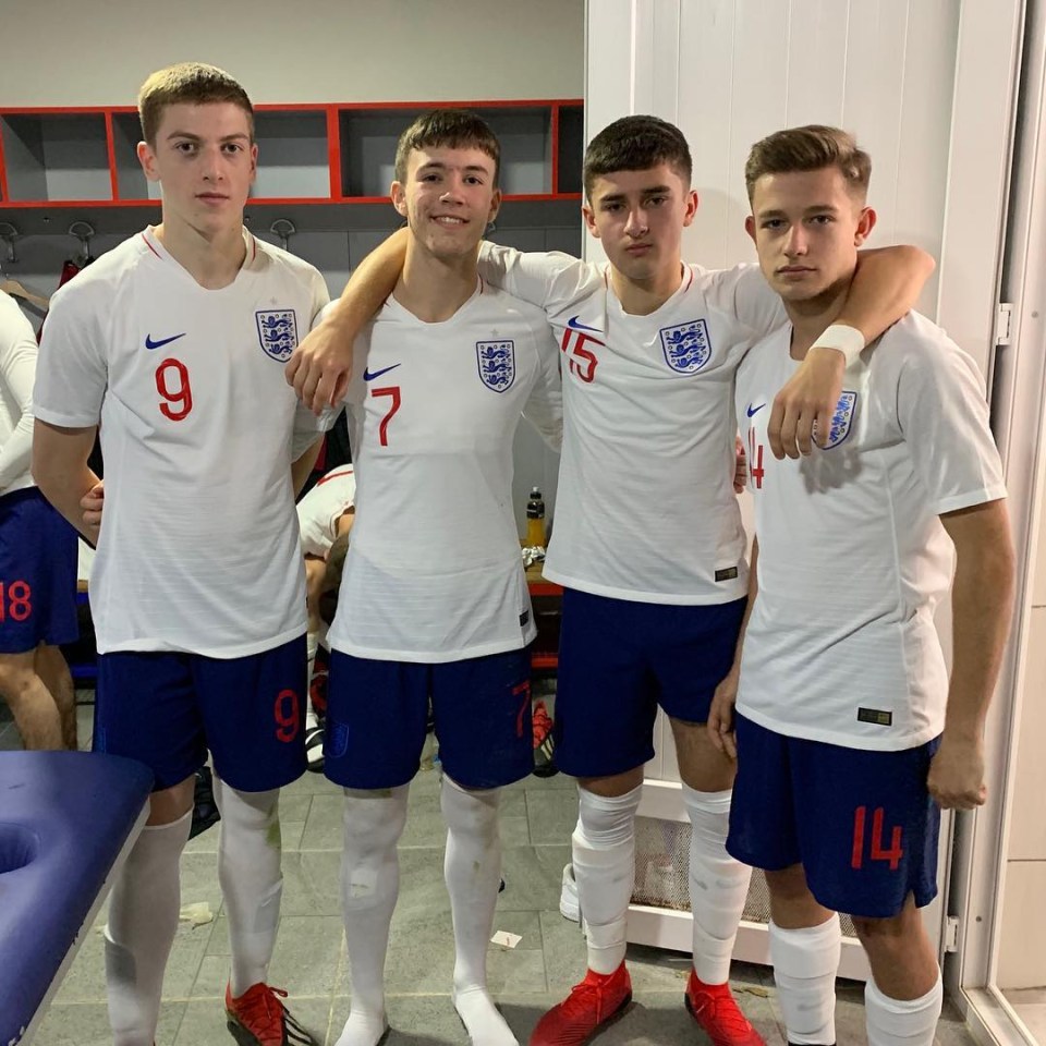 Four young men in England soccer uniforms.