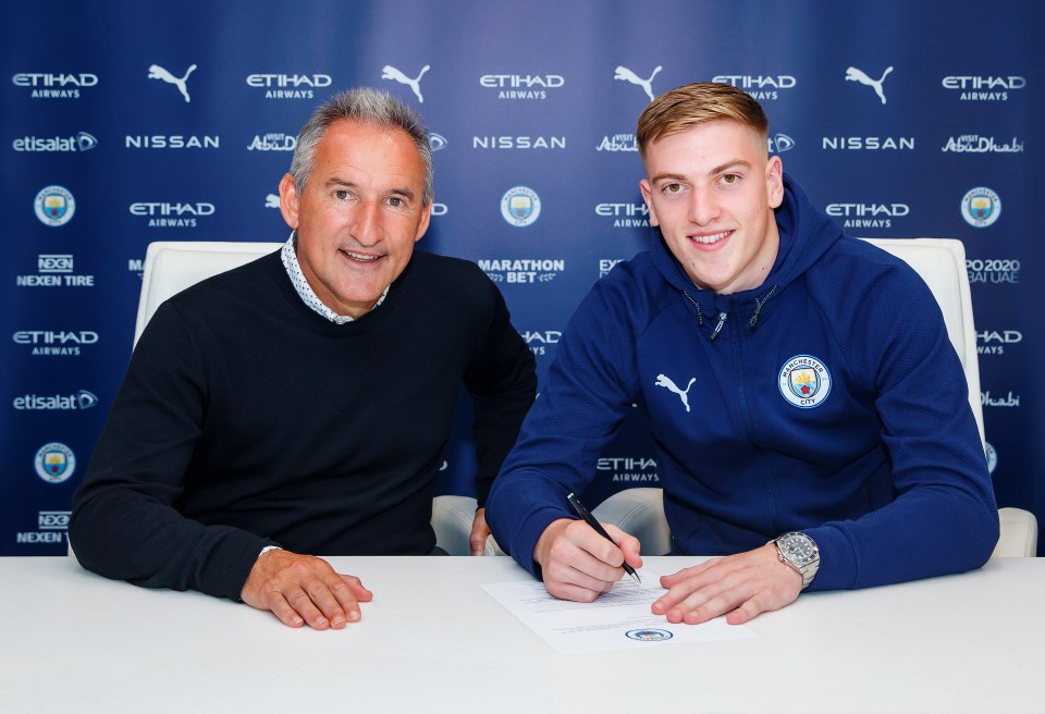 Liam Delap signing a Manchester City contract with Txiki Begiristain.