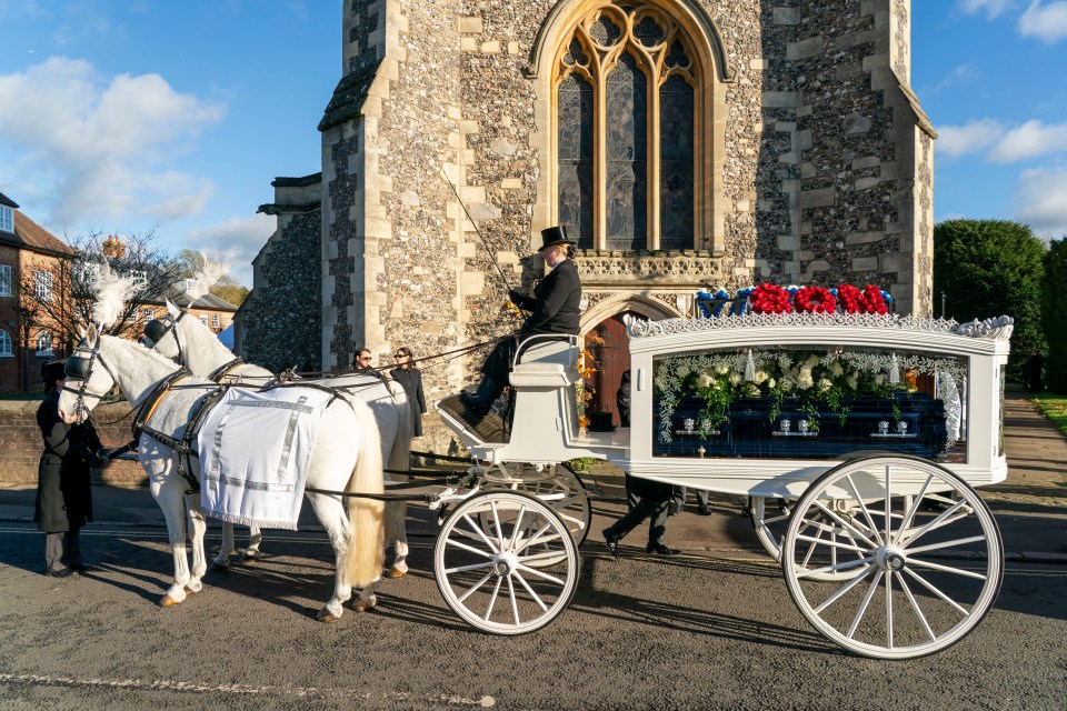 A horse-drawn hearse carrying a coffin at a funeral.