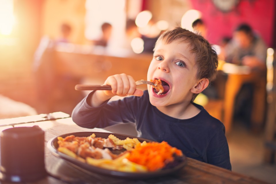 Young boy enjoying a restaurant meal.