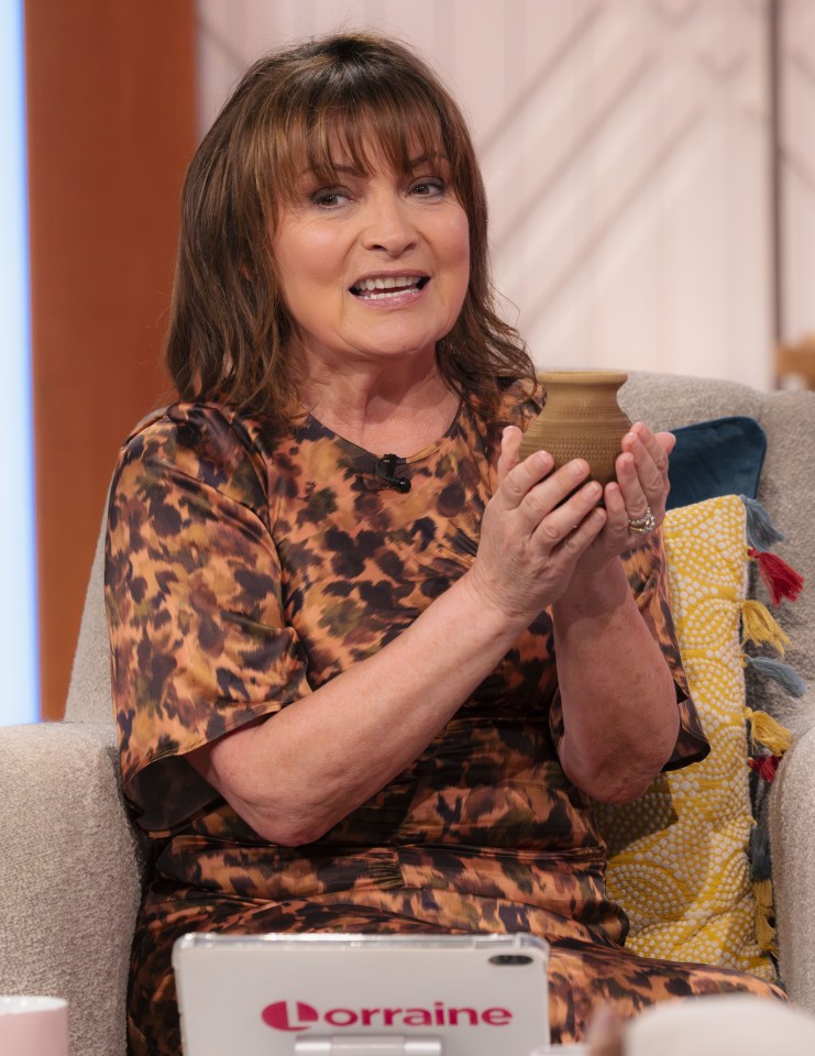 Lorraine Kelly on her TV show holding a small pottery vessel.