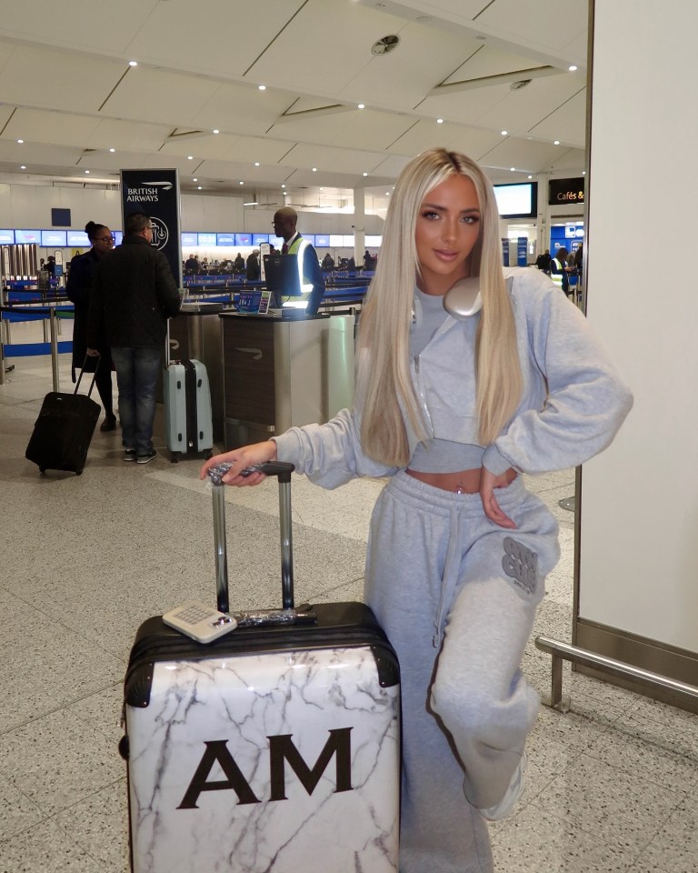 Woman at an airport with a marble suitcase.