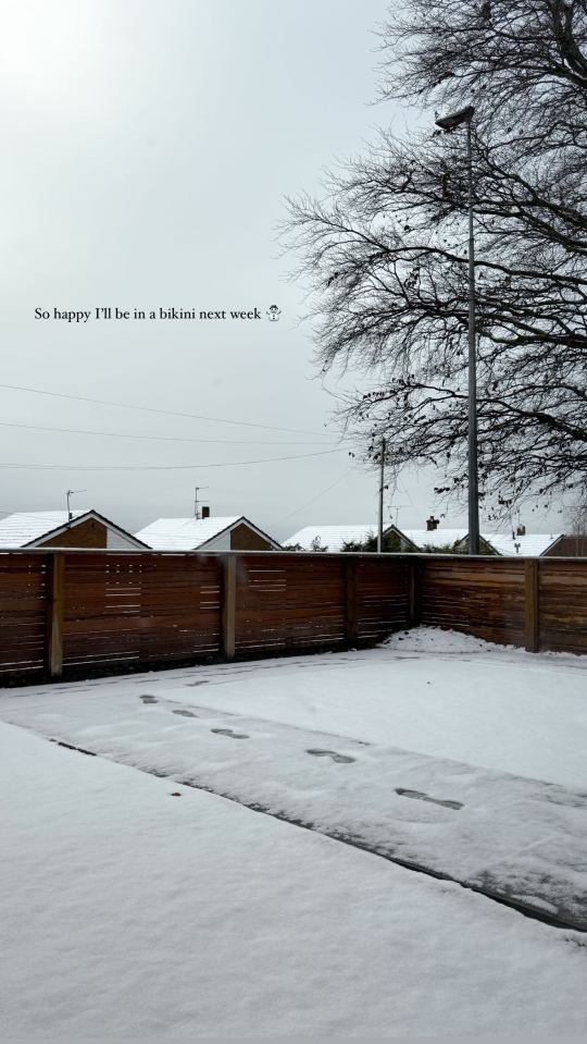 Snow-covered yard with footprints leading to a wooden fence; text overlay: "So happy I'll be in a bikini next week."