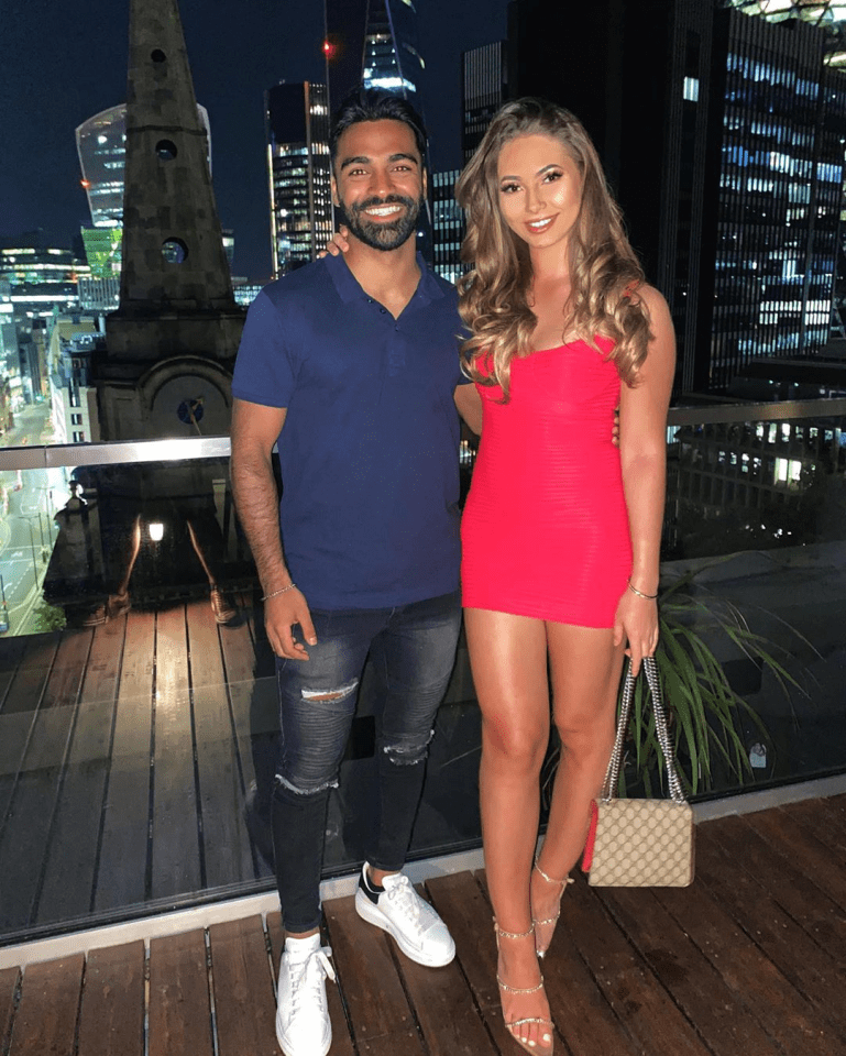 Couple posing on a rooftop terrace at night.