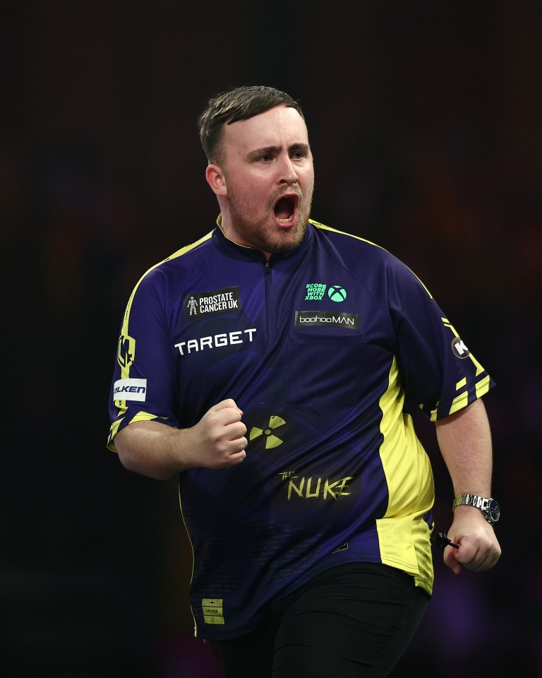 Luke Littler celebrates during a darts match.