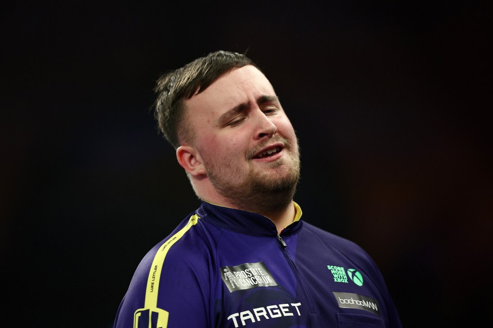 Luke Littler of England reacts during a darts match.