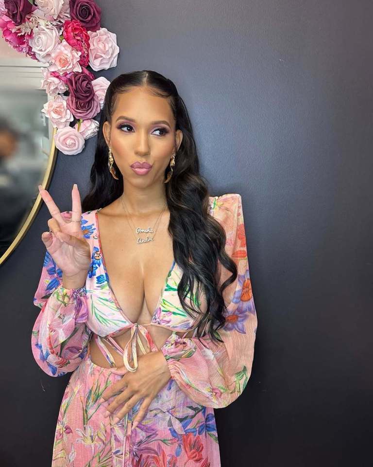 Woman in floral dress making peace sign.