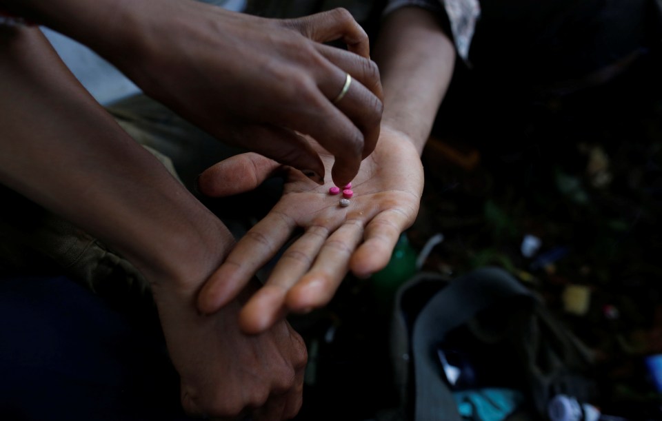 Men handling pills on a street.