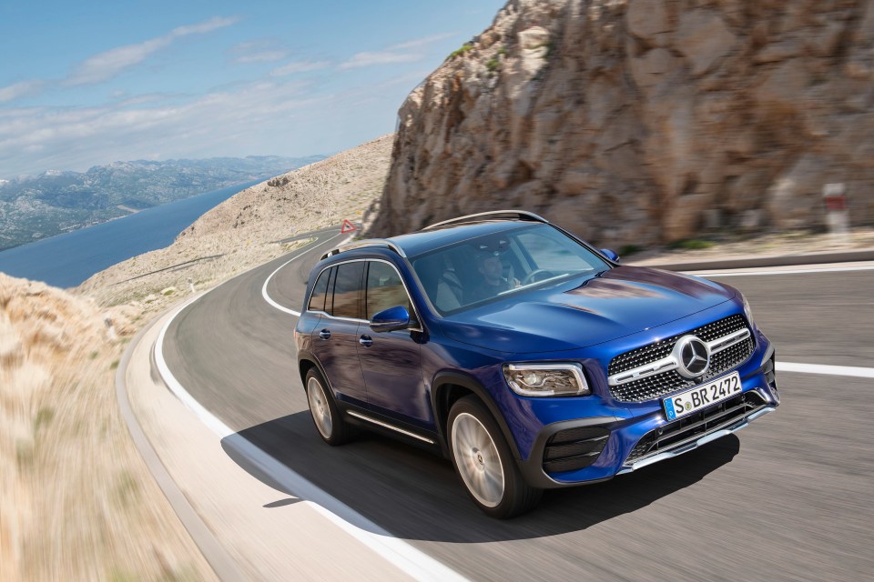 Blue Mercedes-Benz GLB driving on a coastal road.