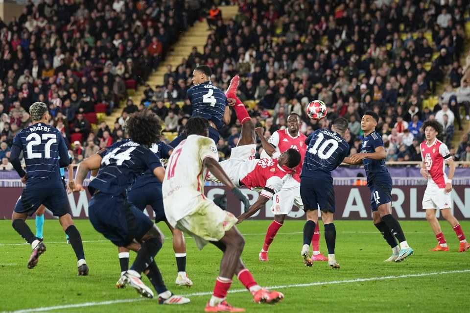 Soccer player attempting an overhead kick during a match.