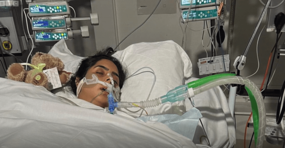 Woman in hospital bed on ventilator.