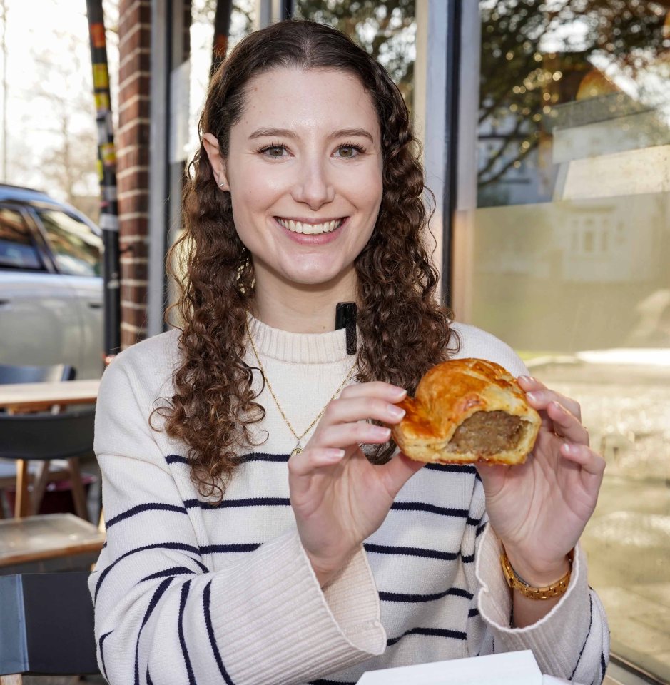 Woman holding a sausage roll.