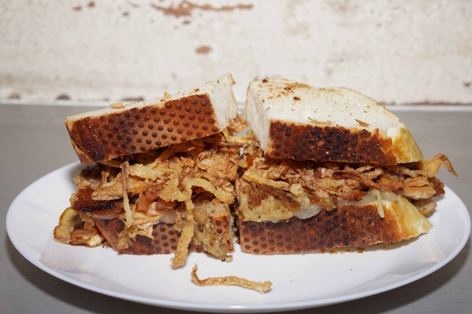 Pulled pork sandwich with crispy onions.