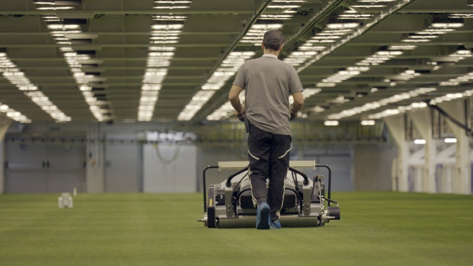 Gardener mowing lawn indoors.