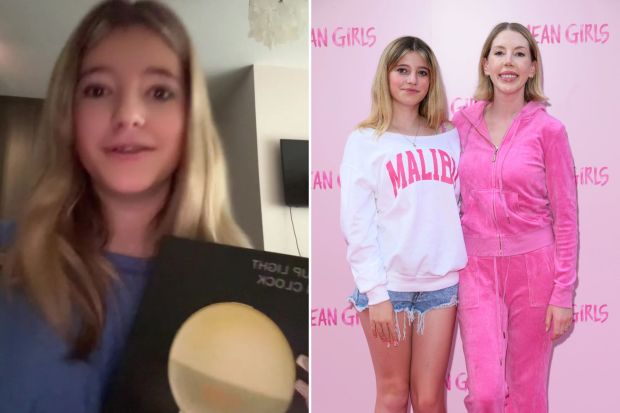 A young girl holding a record and a photo of her with a woman at a Mean Girls event.