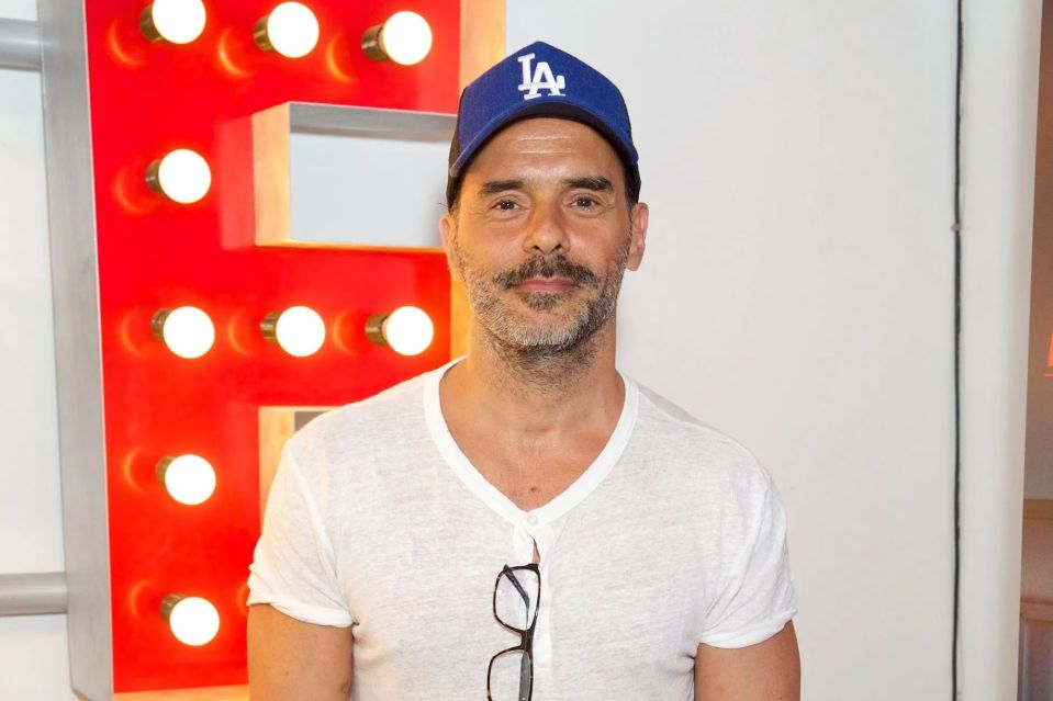 Portrait of a man wearing a white shirt and a baseball cap.