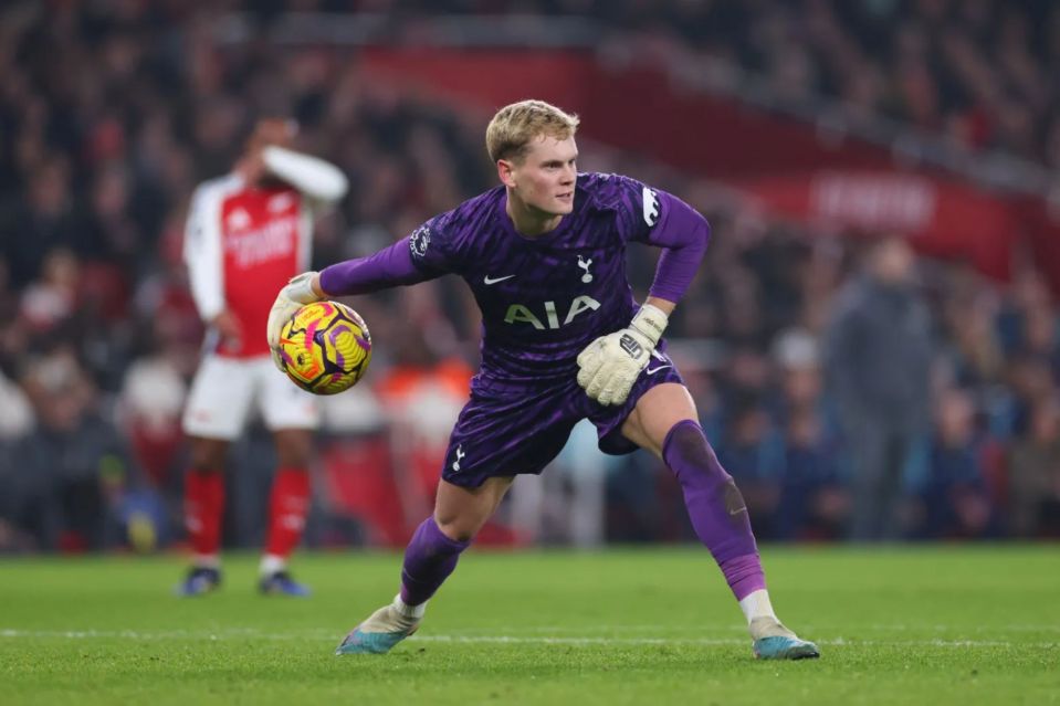 Soccer goalie in purple uniform making a save.