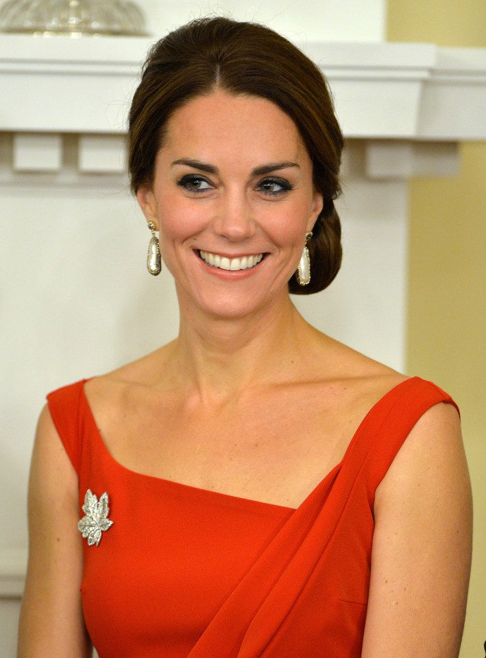 Catherine, Duchess of Cambridge, smiling in a red dress.