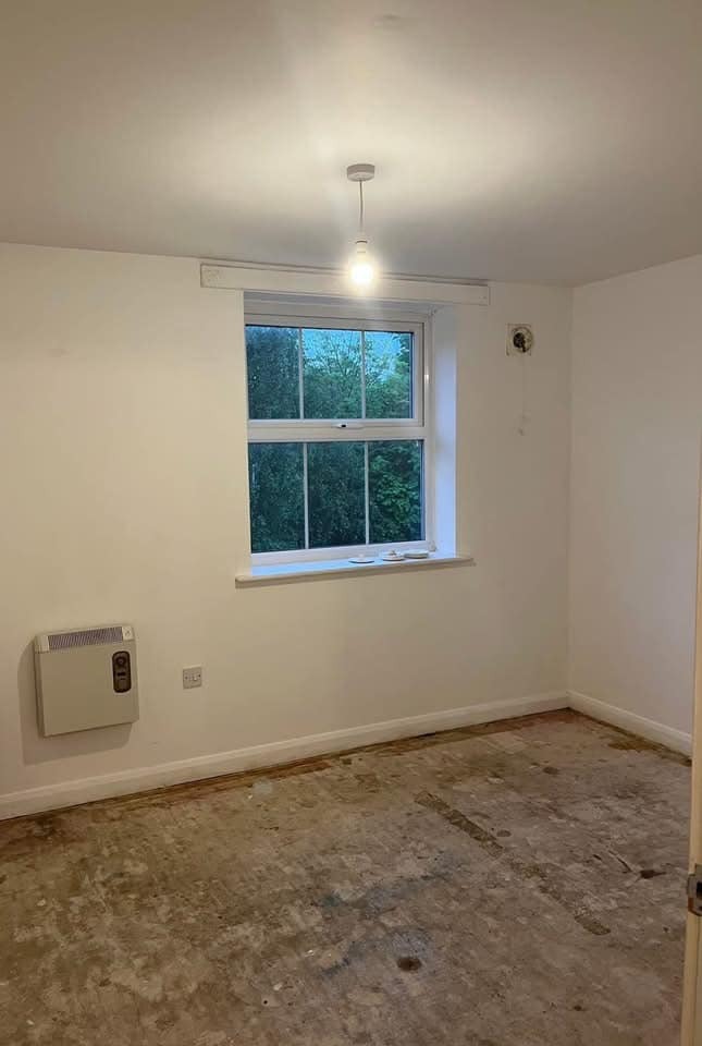 Empty room with bare floor and a window.