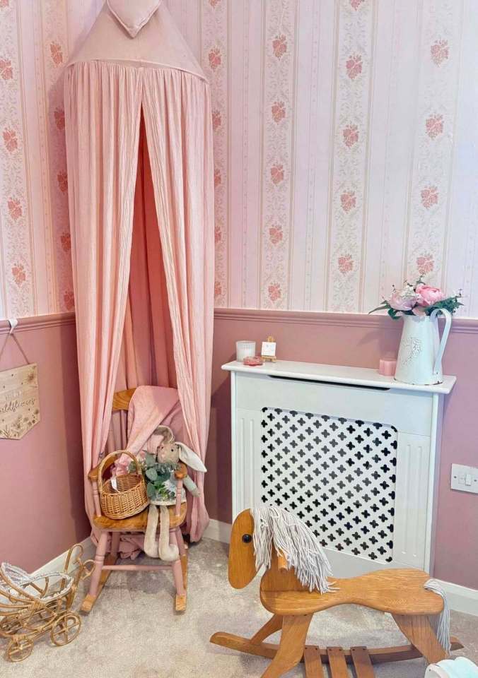 Girl's bedroom corner with pink canopy, rocking chair, rocking horse, and radiator cover.