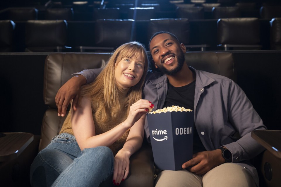 Couple enjoying a movie and popcorn at the Odeon cinema.