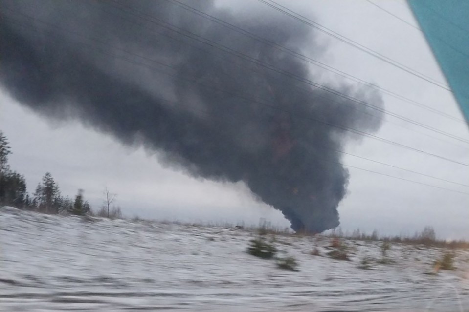 Large plume of black smoke rising from an oil depot fire.