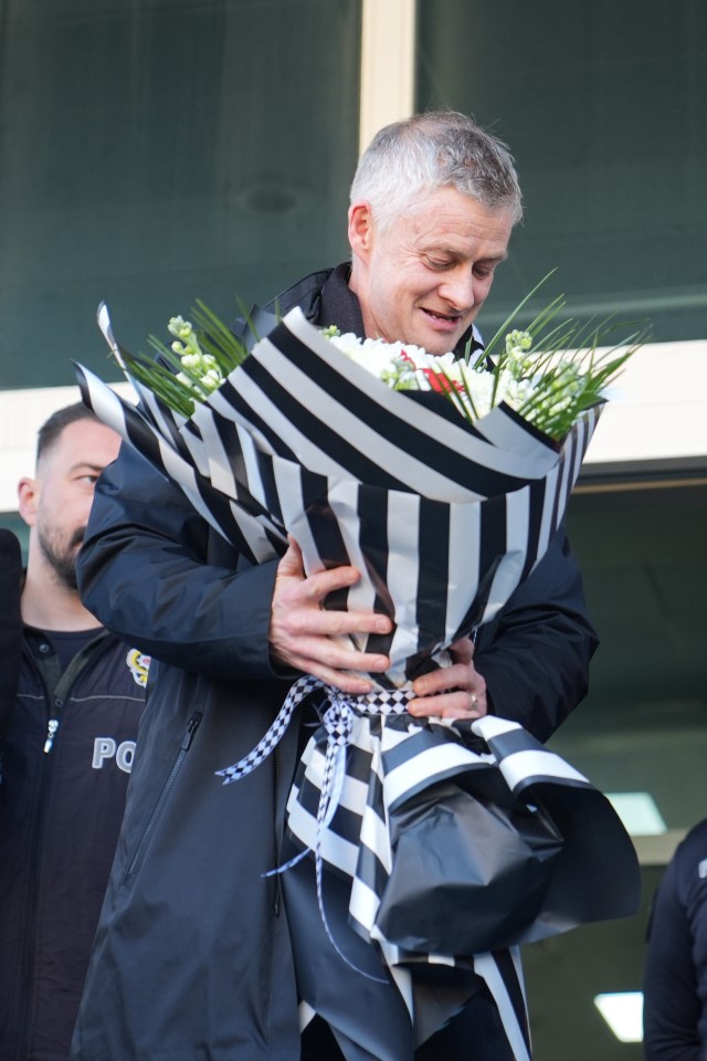 Ole Gunnar Solskjaer holding a bouquet of flowers.