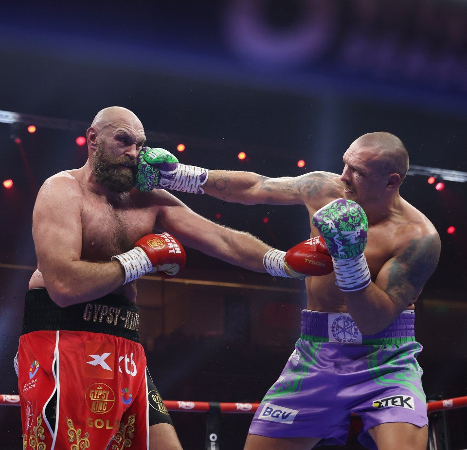 Oleksandr Usyk punches Tyson Fury during a boxing match.