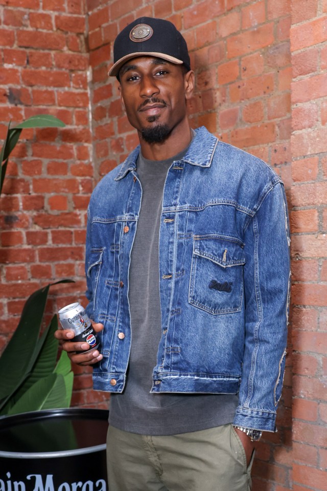 Ovie Soko holding a Captain Morgan can at an event.