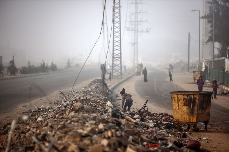 A Palestinian girl searches through rubble in Deir al-Balah, Gaza Strip.