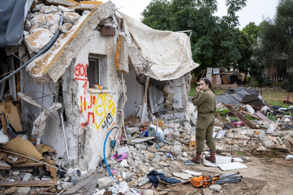 A soldier surveys the damage to a destroyed building.