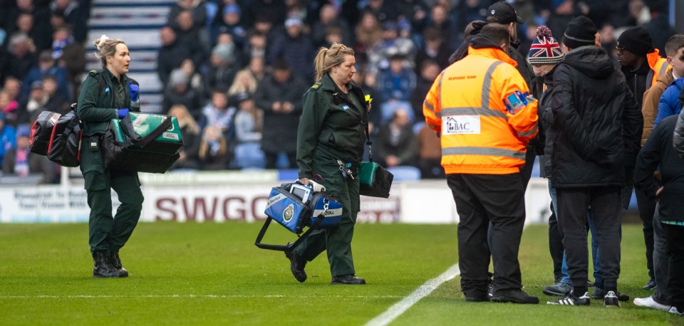 Paramedics attending a medical emergency at a sporting event.