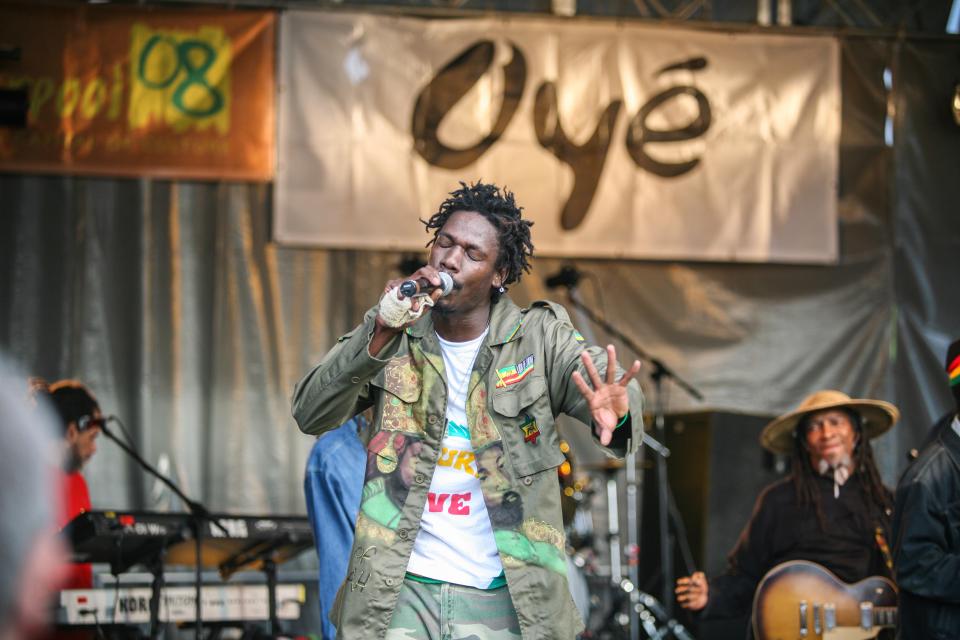 A man singing into a microphone at the Africa Oye music festival.