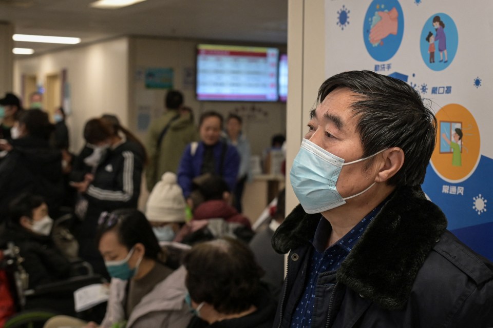 Masked people waiting in a hospital outpatient area.