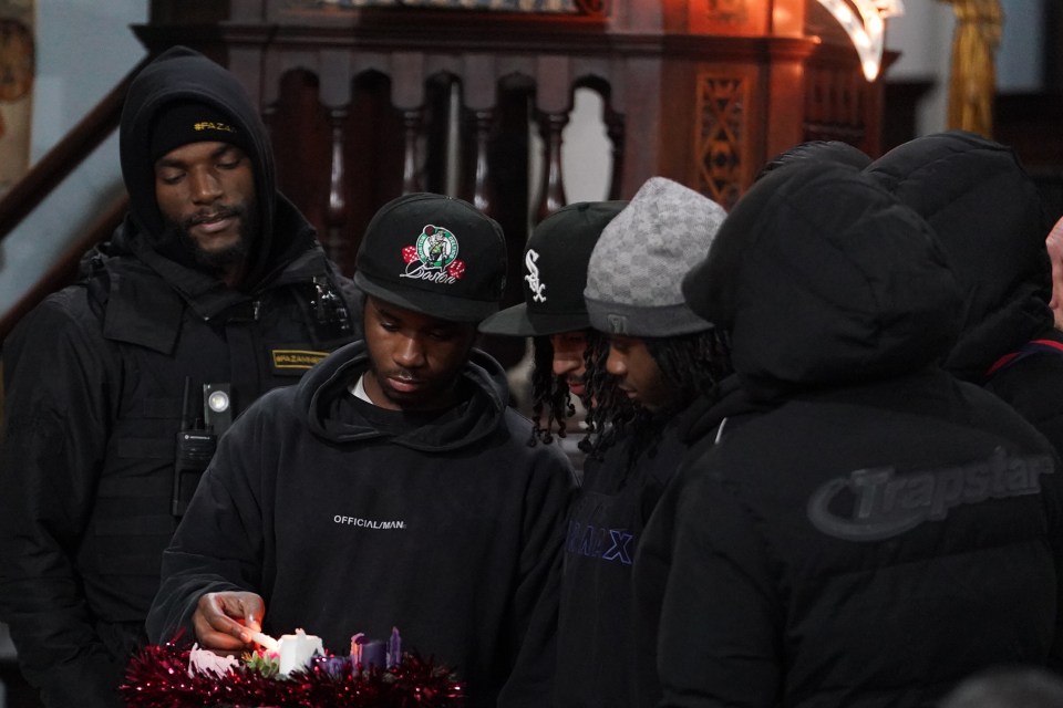 A person lighting a candle during a vigil at St Mary Magdalene church in Woolwich