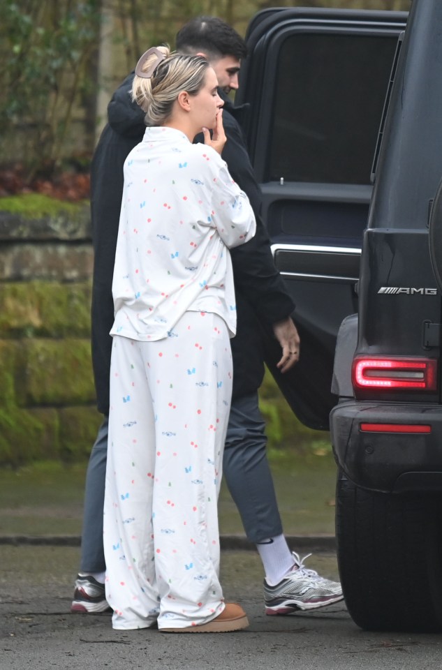 Molly in pajamas with a man near a car.