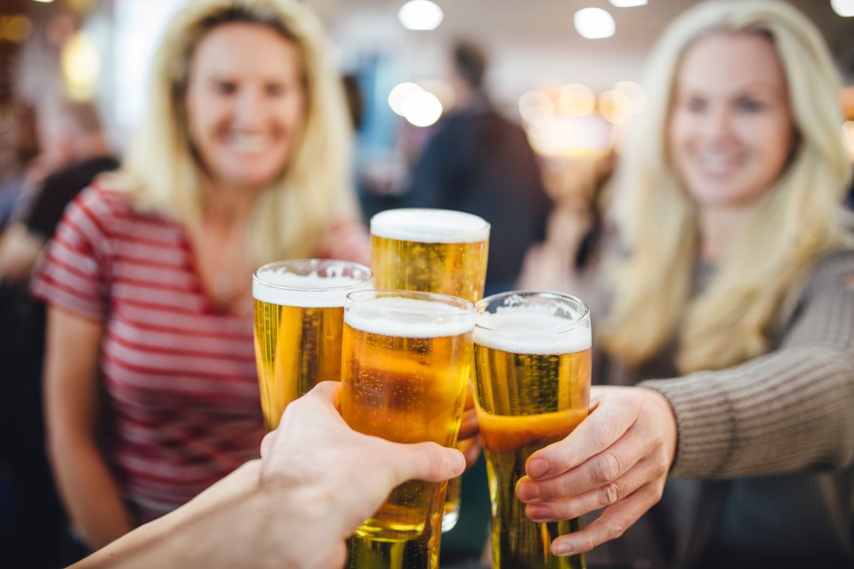 Friends toasting beers at an airport bar.