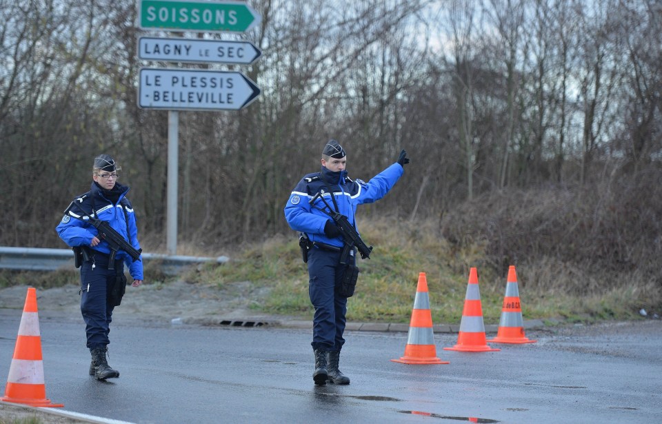 Police officers block a road near the industrial site where the brothers were hiding