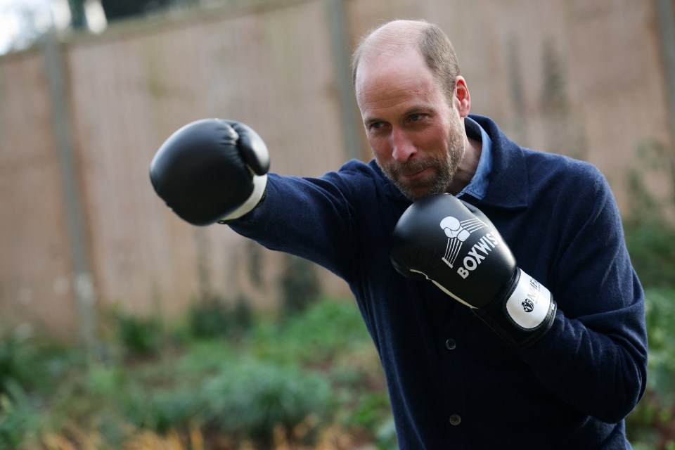 Prince William wearing boxing gloves.